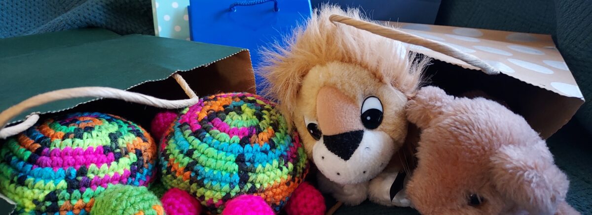 Two toy lions and two toy turtles peer out of gift bags