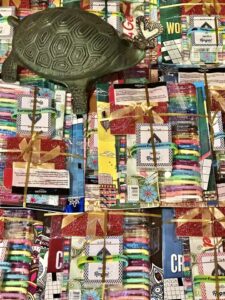 A statue of a turtle with a butterfly on its nose on top of gift packages for older kids