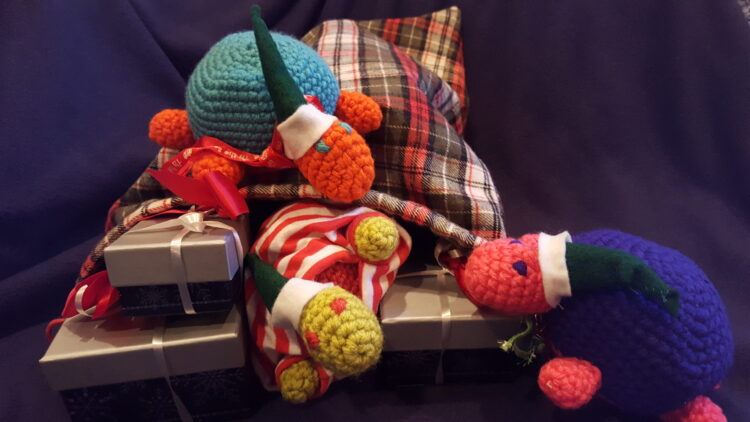 Turtles in elf hats pack gift boxes into a sack