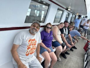 A happy crowd sitting on deck near their fishing poles