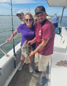 A man and a woman proudly display their catch