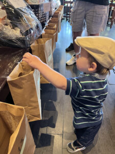 Child dropping raffle ticket into bag hoping to win a prize