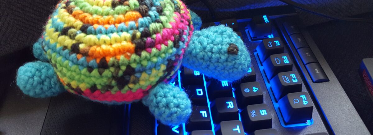 A toy turtle typing on a computer keyboard