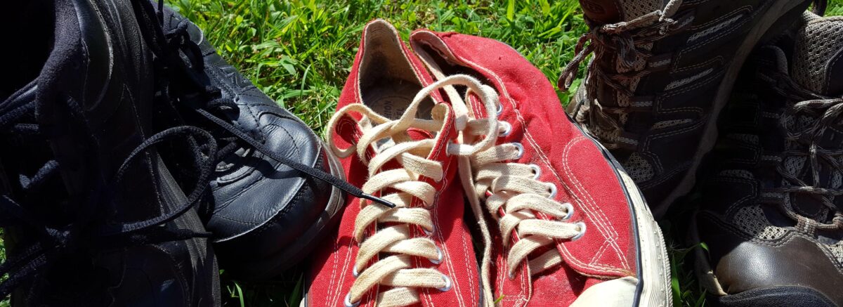 Three pairs of well-worn sneakers ready to take a long walk for St Jude