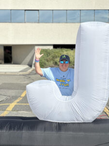 Jeanine poses behind the letter J