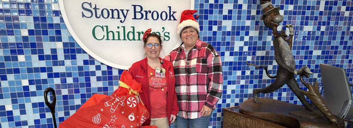 Jeanine Spencer and a Child Life staff member with a wagon full of holiday gifts