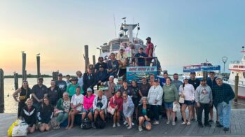 Friends of The Spencer Foundation pose on the dock in front of the Captain Eddie B III