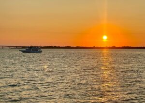 The sky shimmers orange over the bay as the sun nears the horizon