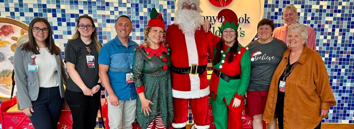 Santa, elves and Jeanine Spencer with Joan Alpers and the Child Life staff at Stony Brook Children's Hospital